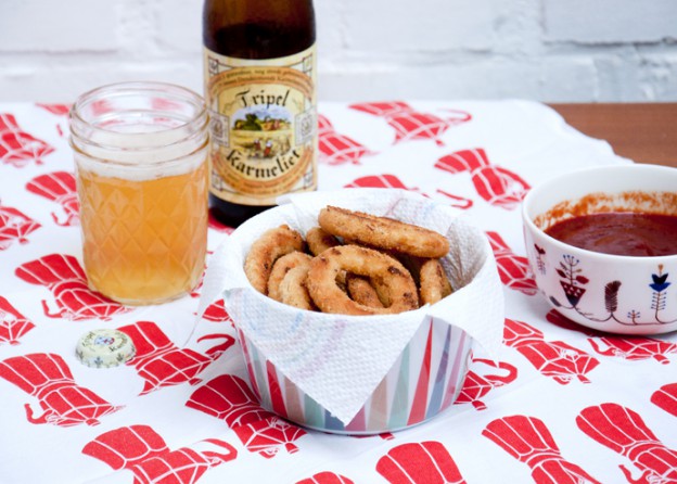 Cheats onion rings met ketchup barbecue dip.